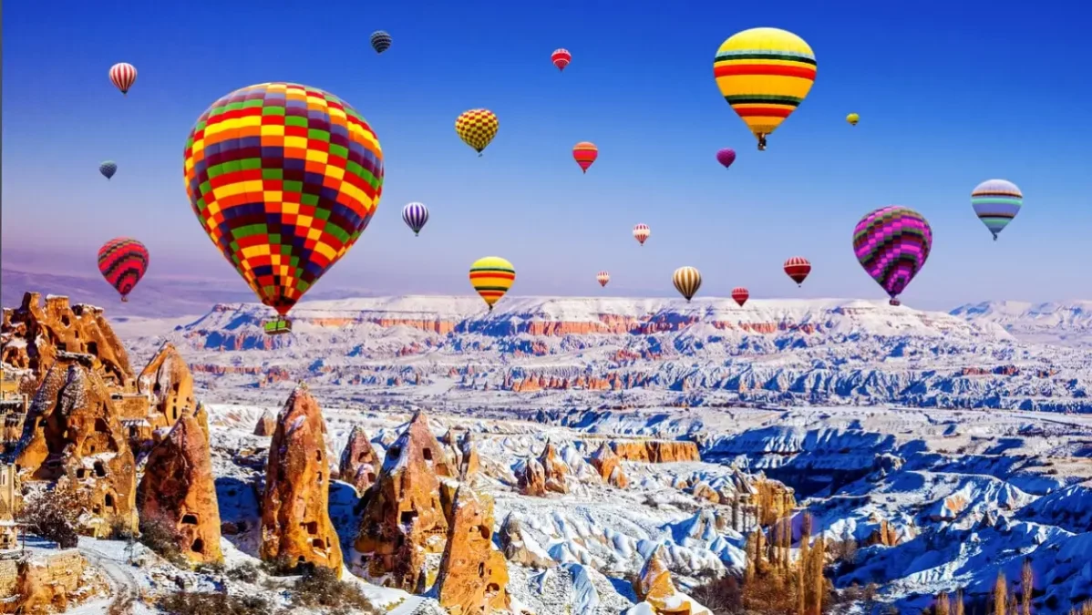 Kapadokya, Nevşehir'in karlı görüntüsü. Balonlar uçuyor.